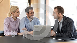 Male realtor consult excited young couple at meeting
