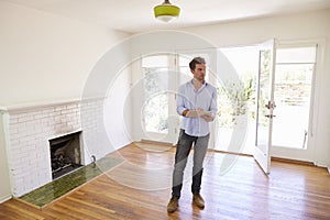 Male Realtor With Digital Tablet Looking Around House