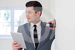 Male Realtor With Digital Tablet Measuring Room With Laser Measure