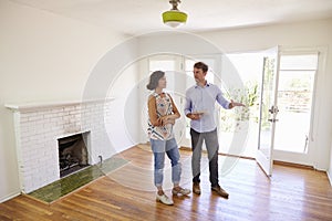 Male Realtor Showing Female Client Around House