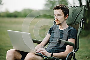 Male relaxing and work on vacation. Young man using online banking for sending money everywhere. Male traveler blogger work remote