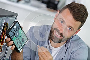 Male repairman trying to fix computer