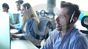 Male representative call center agent in wireless headset helping client in customer support service