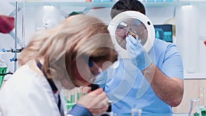 Male researcher looking at strawberry samples under a magnifying glass