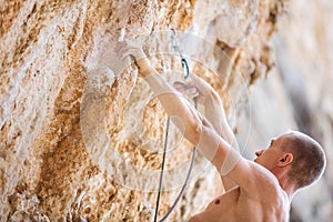 Male rock climber clipping rope