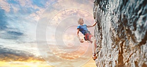 Male rock climber resting while climbing the challenging route on the rocky wall