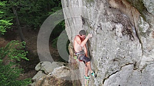 Male rock climber training rock climbing on a huge boulder