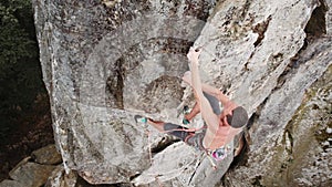 Male rock climber training rock climbing on a huge boulder