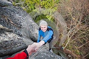 Male rockclimber is helping a climber female