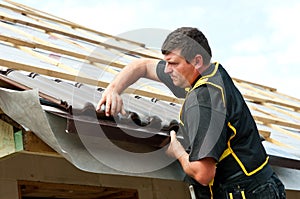 Male roofer fitting tiles