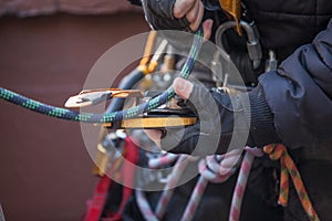 Male rope access worker dressing with industry fall protection yellow helmet abseiling safety body harness prior to work