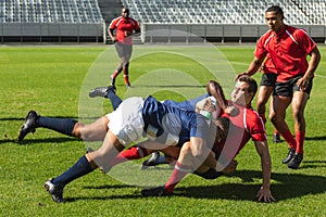 Male rugby players playing rugby match in stadium