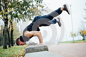 Male runner doing exercise, workout in the fall park. Push ups with bench.