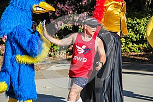Male runner high-fives woodpecker mascot in a charity race