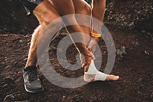Male runner holding injured bandaging leg close-up
