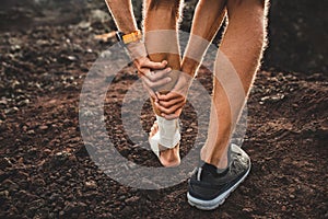 Male runner holding injured calf muscle close-up