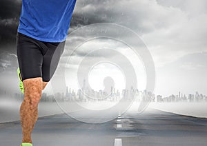 Male runner legs on road with skyline and storm