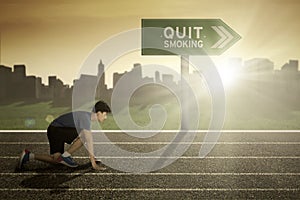 Male runner with quit smoking word on signpost