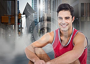 Male runner sitting on arrow shaped road in street