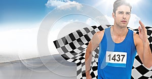 Male runner sprinting on road against sky and sun with flare and checkered flag