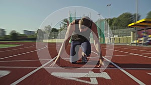 A male runner on the track prepares to run and abruptly starts, blur shooting