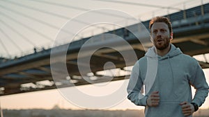 Male runner using earphone and fitness tracker outdoors