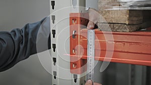 Male`s Hands With Precision Measuring Tool. Engineer Makes Measurement of The Beam At The Storage, Close Up Shot