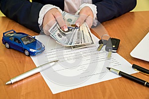 Male`s hands signing on car contract claim form and calculator, dollar