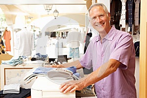 Male Sales Assistant At Checkout Of Clothing Store