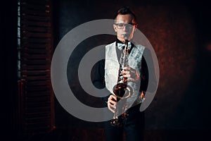 Male saxophonist playing jazz melody on saxophone