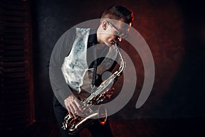 Male saxophonist playing jazz melody on saxophone