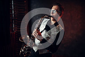 Male saxophonist playing jazz melody on saxophone