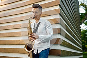 Male saxophonist plays melody on the street