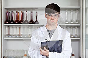 Male science student writing on a clipboard