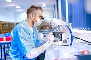 Male scientist, chemist working with microscope in pharmacy