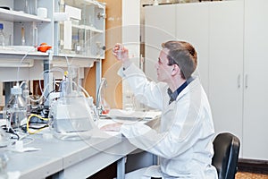 Male scientist conducts chemical experiments with liquids in science lab