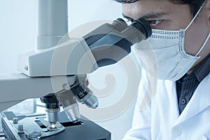 Male scientist doing microscope for chemistry test samples, examining. Laboratory equipment and science experiments