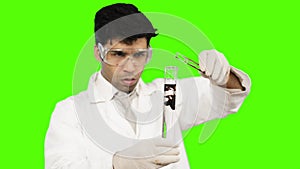 Male scientist experimenting in a laboratory against green background