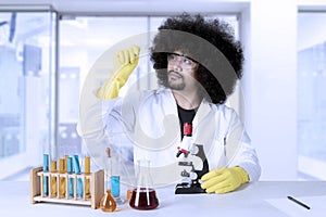 Male scientist looking microscope slide