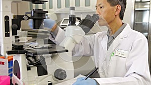 Male Scientist Using Microscope In Laboratory