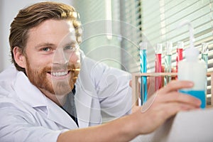 male scientist working with colorful test tubes
