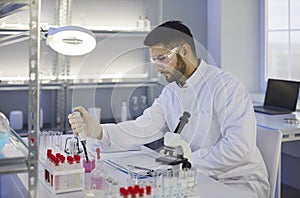 Male scientist is working on development of new drug in laboratory of modern pharmaceuticals.