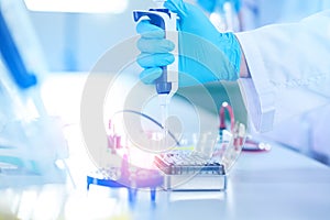 Male scientist working at the laboratory. Cloud up medical hand using micro pipette for test analysis. Scientific Lab for Medicine