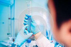 Male Scientist working in laboratory, comparing liquid substances and testing samples