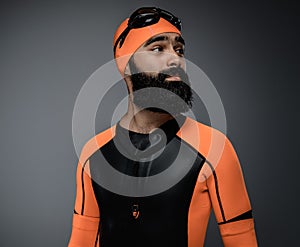 Male in scuba diving mask and orange neopren diving suit.