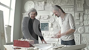 Male sculptor with grey hair suggesting molding pieces