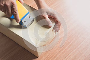 Male sealing with tape small box for moving. Close up of a hands