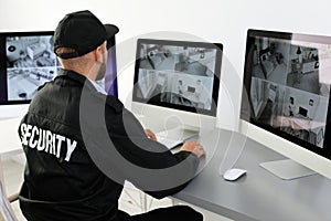 Male security guard monitoring home cameras