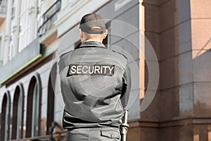 Male security guard outdoors, back view