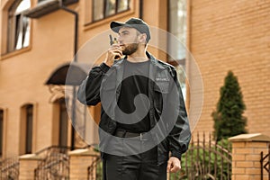 Male security guard with portable radio transmitter outdoors
